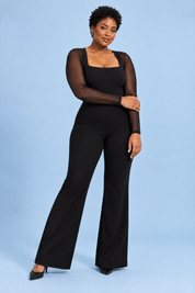 Combinaison noire à jambes évasées et manches transparentes | Porté sur une silhouette plus ronde | Lounelle Paris