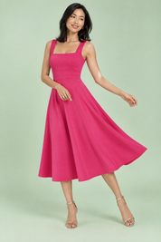 Robe midi rose vif à fines bretelles et jupe évasée | Vue en mouvement | Lounelle Paris